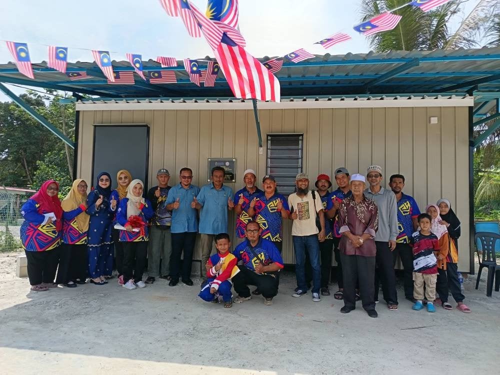 Mohd Isam (tengah) bergambar bersama penduduk Kampung Gemencheh Lama pada Majlis Perasmian Projek Sejati Madani JPKK Kampung Gemencheh Lama, di sini, hari ini.