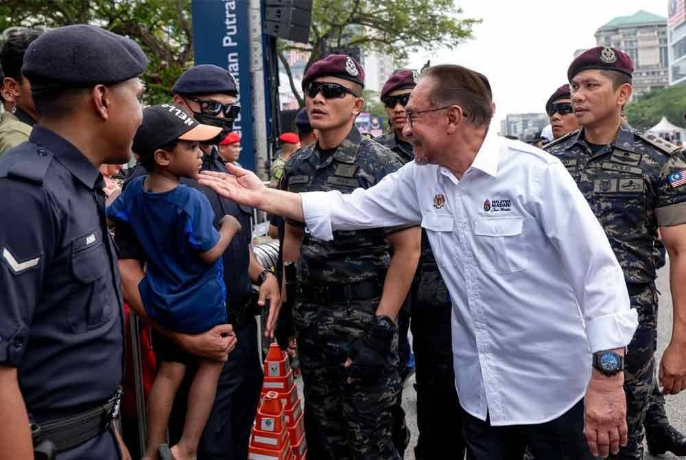Anwar turut beramah mesra dengan pengunjung yang bersama-sama menyemarakkan sambutan Hari Kebangsaan ke-67 di Dataran Putrajaya, pada Sabtu. Foto Facebook Anwar Ibrahim