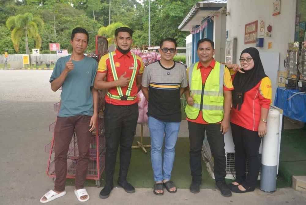 Mohd Azmawi Fikri (tengah) bersama penduduk tempatan serta pekerja stesen minyak berdekatan kawasan Rehat dan Rawat (RNR) Rantau Manis, Gua Musang.