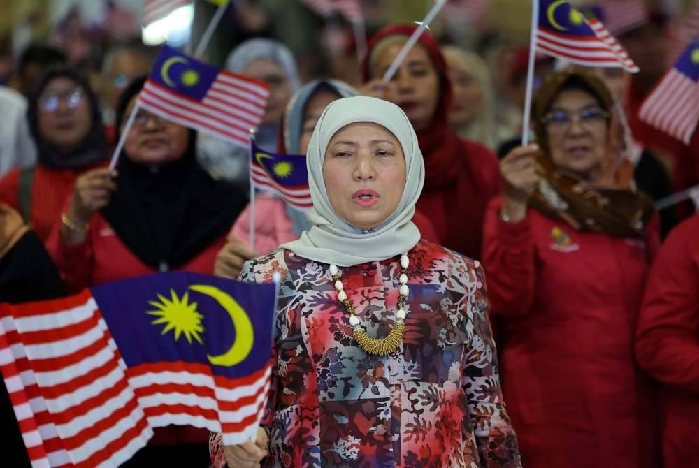 Nancy Shukri mengibarkan Jalur Germilang ketika hadir pada Program Jiwa Komuniti Madani peringkat Parlimen Santubong, hari ini. Foto Bernama