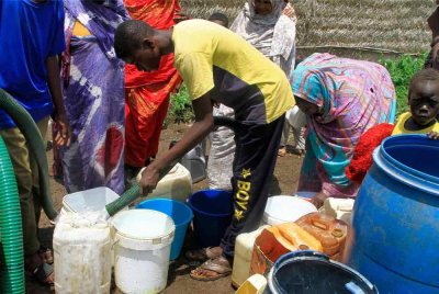 Masyarakat setempat mengumpul air bersih yang disediakan oleh pertubuhan amal kepada orang ramai di Gedaref di timur Sudan pada Jumaat - Foto: AFP