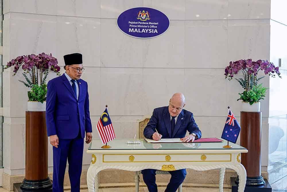 Perdana Menteri Datuk Seri Anwar Ibrahim menyaksikan Perdana Menteri New Zealand Christopher Luxon menandatangani buku pelawat sempena lawatannya ke Malaysia di Bangunan Perdana Putra, di sini hari ini.