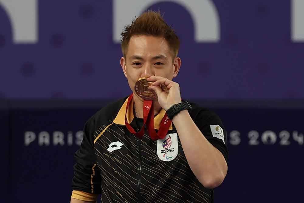 Liek Hou mencium pingat emas yang dimenangi dalam acara perseorangan lelaki SU5 (kecacatan fizikal) Sukan Paralimpik Paris 2024. Foto Bernama
