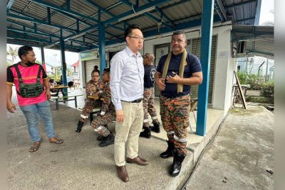 Jimmy Puah diberikan taklimat oleh pegawai bomba di lokasi kejadian.