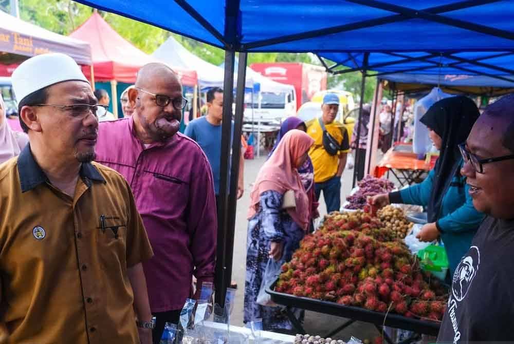 Muhammad Khairi (kiri) melawat gerai jualan yang terdapat di Program jualan Pasar Berkat.