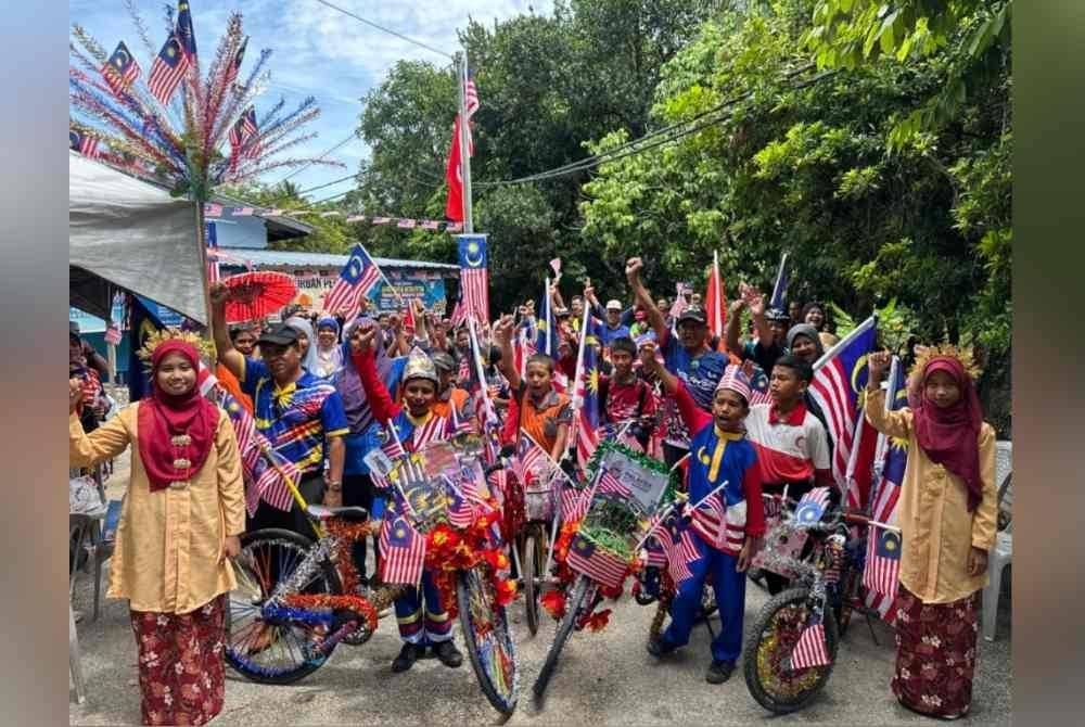Murid SK Jeram yang menghias basikal dengan Jalur Gemilang.