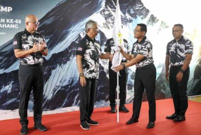 Sultan Pahang Al-Sultan Abdullah Ri'ayatuddin Al-Mustafa Billah Shah berkenan menyempurnakan penyerahan bendera ekspedisi kepada Pengelola Bijaya Diraja Sultan Pahang Datuk Ahmad Khirrizal Al Rahman (dua, kanan) pada Majlis Penyerahan Bendera Ekpedisi ke Everest Base Camp (EBC) sempena memuliakan Hari Ulang Tahun Keputeraan Ke-65 Sultan Pahang di Bukit Fraser hari ini. - Foto: Bernama