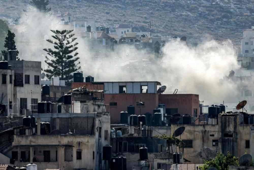 Asap tebal memenuhi ruang udara selepas pertempuran ganas berlaku di kem pelarian Palestin.