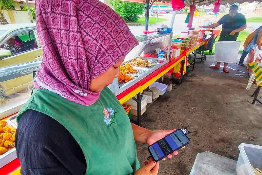 Zainab melihat siaran langsung sidang DUN Pahang menerusi telefon bimbit miliknya pada Khamis.