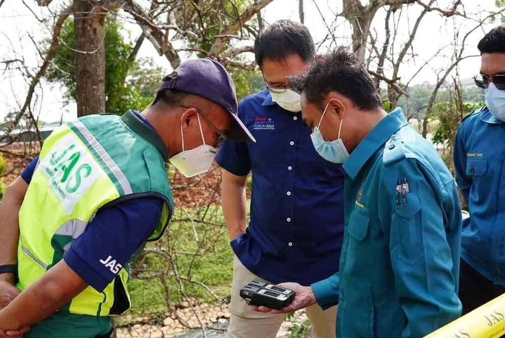 Anggota JAS Johor melakukan pemeriksaan di lokasi penemuan beberapa objek yang tidak dikenal pasti yang dibuang di tepi sungai dalam bentuk bungkusan di anak Sungai Pandan berhampiran Taman Daya Johor Bahru. Foto Tian Soon