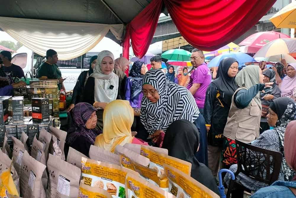 Rozita (kiri) menemui penduduk tempatan yang hadir ke program CSR oleh Yayasan Bonda Rozita di Pasar Taman Sri Tanjung, Sungai Layar, Sungai Petani.