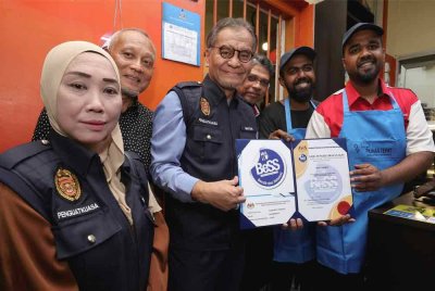 Dr Dzulkefly (tiga, kiri) menyerahkan Sijil Pengiktirafan Premis 'Bersih dan Selamat' (BeSS) kepada wakil kedai sempena Program Walkabout Premis Bersih, Bebas Asap (BeBAs) di Jalan Dhoby malam Khamis. Foto Bernama