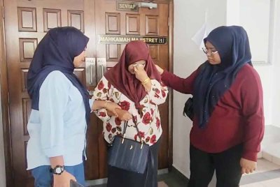Wardah (kanan) menenangkan ibunya Norizan Mat Isa, 43, (tengah) selepas mendengar hukuman yang dikenakan terhadap tertuduh di luar Mahkamah Majistret Melaka pada Jumaat.
