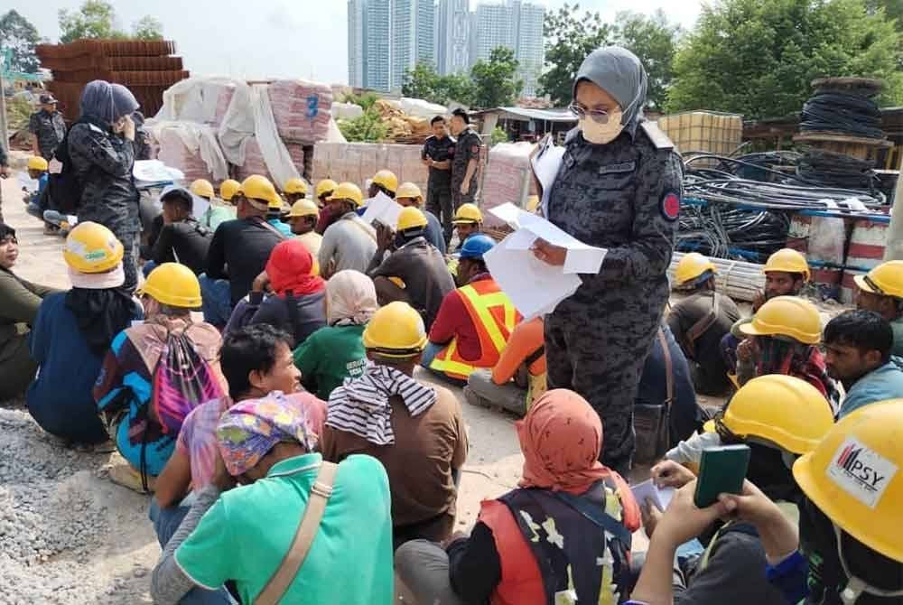 Pegawai JIM Johor, melakukna pemeriksaan dokumen terhadap warga asing yang ditahan.