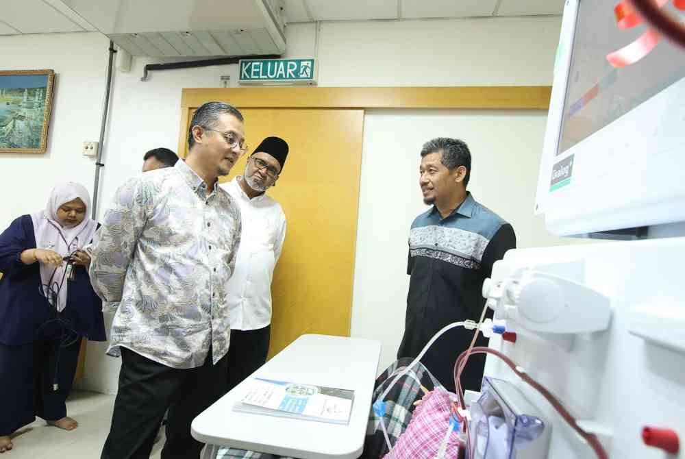 Mohamad (kiri) bertanya sesuatu kepada salah seorang pesakit di PHZ Bayan Baru selepas Majlis Serahan Mesin Dialisis Pusat Hemodialisis ZPP di PHZ Bayan Baru pada Sabtu.