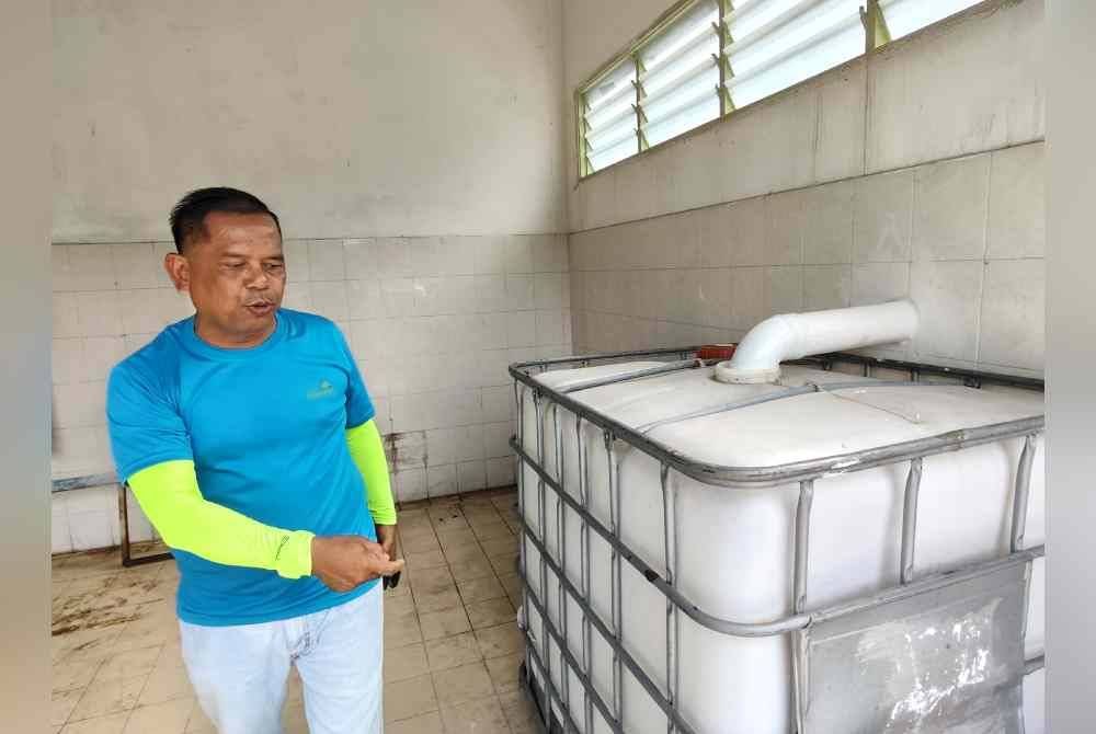 Mohamad Zailani menunjukkan tong yang akan digunakan bagi minyak masak terpakai.