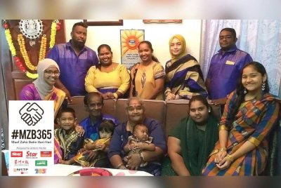 Pusparani (duduk, tengah) ketika menyambut Deepavali bersama Muhammad Syafiq (berdiri, kanan) dan ahli keluarganya yang lain di rumahnya di Kampung Kolam.