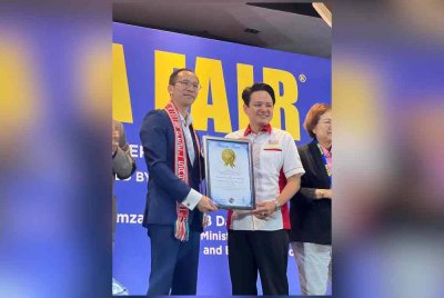 Nigel (kiri) menerima sijil daripada wakil Malaysia Book of Records selepas MATTA Fair diiktiraf sebagai 'Largest International Travel Fair'.