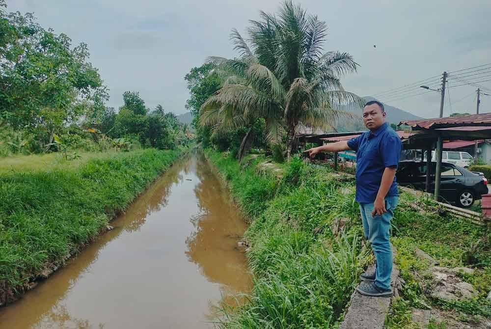 Mohd Izuan menunjukkan tali air di hadapan rumah penduduk di Taman Ilham yang menjadi punca banjir kilat.