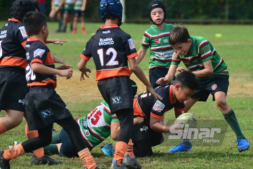 Pasukan bawah 11 tahun Elmina Bronco (jersi oren) memberikan saingan kepada pasukan KL Tigers dalam perlawanan liga pada Ahad. Foto Sinar Harian - ASRIL ASWANDI SHUKOR