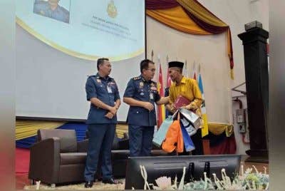 Zainal menyampaikan cenderahati kepada seorang pesara bomba ketika Majlis Perhimpunan Bulanan JBPM pada Ahad.