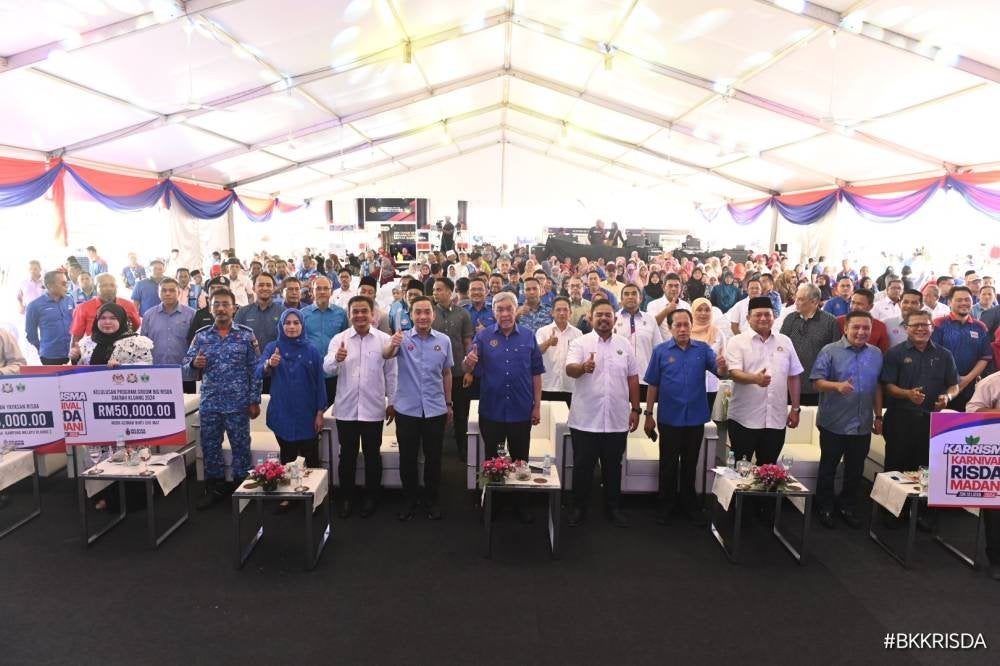 Ahmad Zahid (tengah) dan Manndzri bersama tetamu yang hadir pada program Karnival RISDA Madani (KARRISMA) di Dataran Uptown Kluang, pada Sabtu.