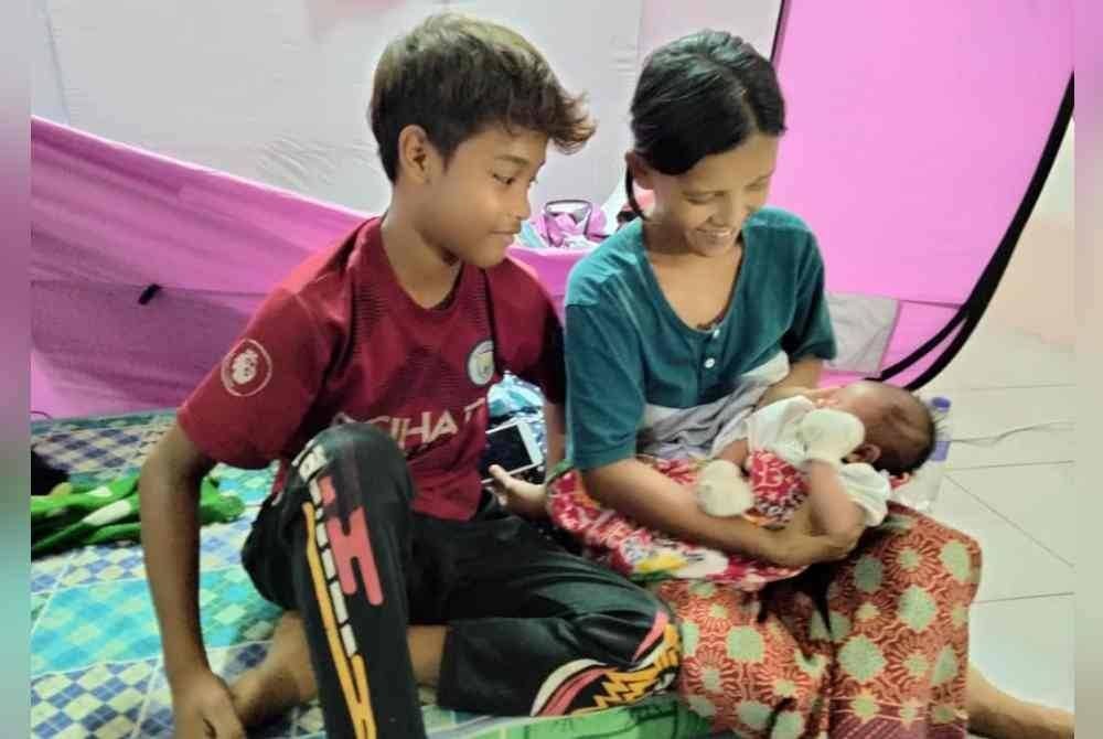 Rozaha bersama anak dan bayinya yang ditempatkan di Balai Raya Kampung Orang Asli Kampung Sayong Pinang, Kota Tinggi.