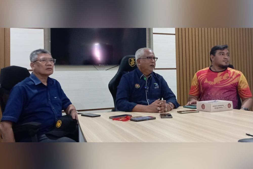 Mahfuz (tengah) ketika ditemui pemberita di Kampung Durian pada Isnin.