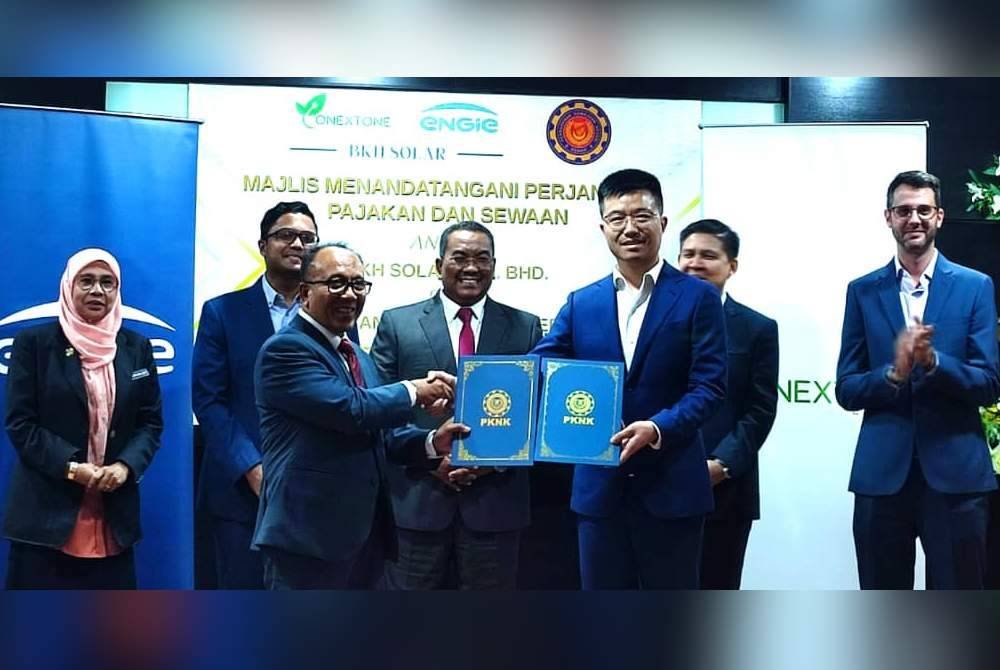 Muhammad Sanusi (tengah) menyaksikan pertukaran dokumen perjanjian bagi Projek Pembangunan Loji Tenaga Solar Berskala Besar di bawah CGPP di Bukit Kayu Hitam.