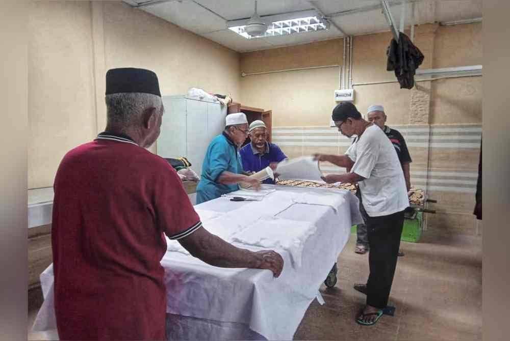 Penduduk menyiapkan urusan pengebumian Allahyarham Kamaruddin pada Isnin.