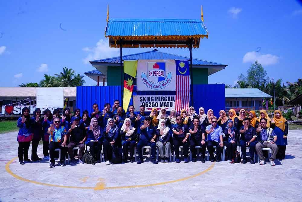 Fadhlina (duduk, tujuh dari kanan) bergambar kenangan bersama Ahmad Johnie, pegawai-pegawai kanan KPM dan warga sekolah Kebangsaan Kampung Pergau.