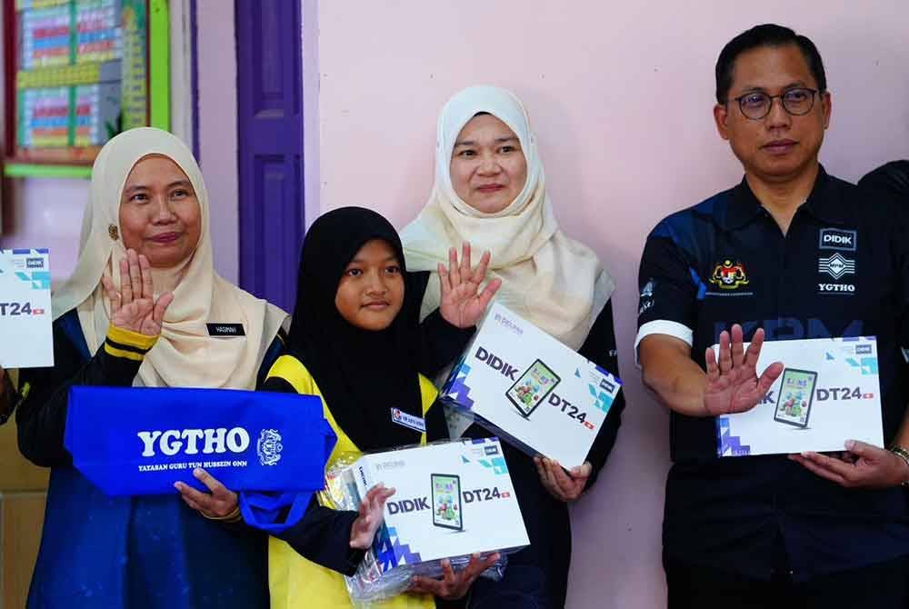 Sumbangan peranti daripada Yayasan Didik Negara dan kelengkapan alat tulis daripada Yayasan Guru Tun Hussein Onn SMK OYA yang disampaikan Fadhlina (dua dari kanan) kepada murid SMK Jalan Oya.