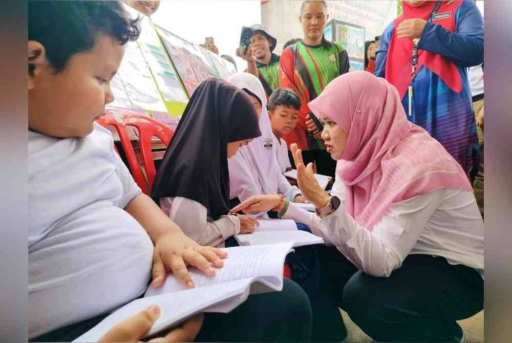 Fadhlina menguji kemampuan membaca murid pra sekolah yang ditemui di SMK RPS Betau pada Ahad.