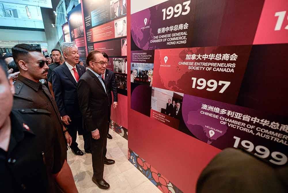 Anwar melihat pameran gambar pada Konvensyen Usahawan Cina Sedunia ke-17 di Pusat Konvensyen Kuala Lumpur pada Selasa. Foto Bernama