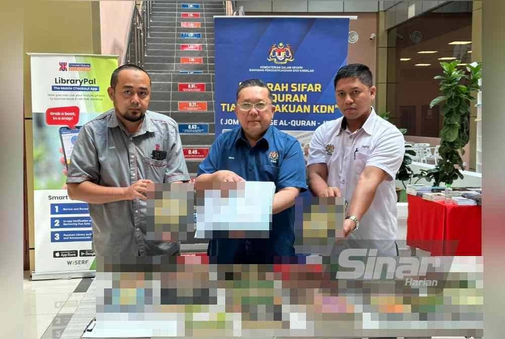 Nik Yusaimi (tengah) menunjukkan cop kelulusan KDN pada al-Quran yang diperakui.