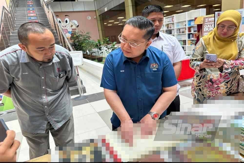 Nik Yusaimi (dua dari kiri) menunjukkan penggunaan tulisan rumi pada ayat al-Quran.