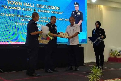 Azizi (dua dari kiri) menyampaikan cenderahati kepada Shamsuddin selepas Program Libat Urus Waspada Penipuan dan Jenayah Semasa di sebuah hotel pada Selasa.