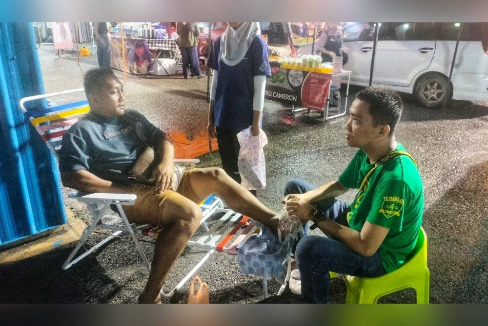 Mohd Ikhwan (kanan) mengurut kaki pelanggan di CBS.