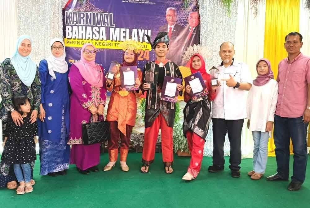 Roslina (tiga dari kiri) bersama Murni Kartika (dua dari kiri) merakam gambar bersama juara sempena Karnival Bahasa Melayu Peringkat Negeri Terengganu yang berlangsung di Sekolah Kebangsaan (SK) Padang Landak, Besut.