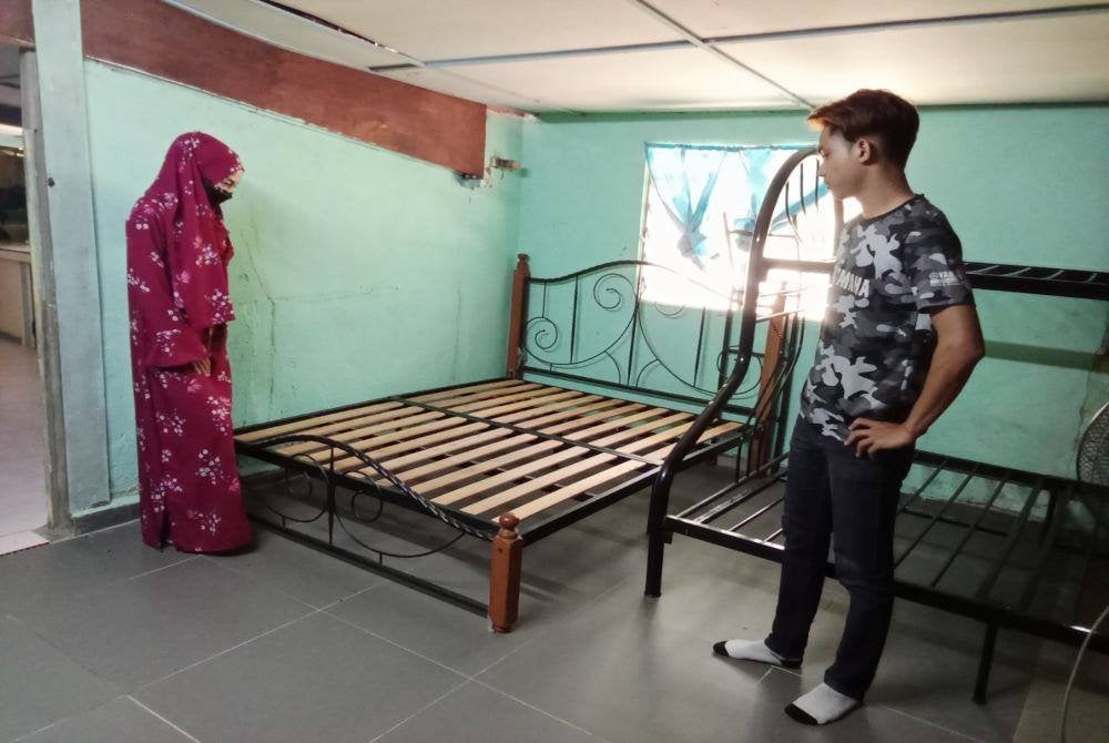 Nor Evawani (kiri) dan Putra ketika menunjukkan tilam di bilik berkenaan terpaksa dibuang kerana rosak akibat beruk.