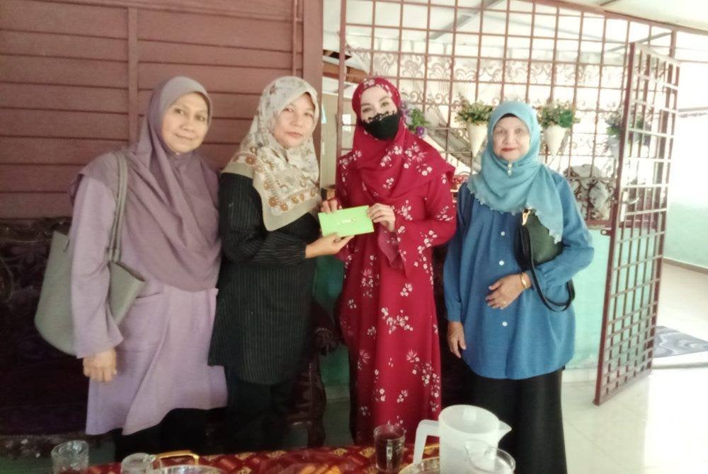 Nor Evawani (dua kanan) ketika menerima sumbangan daripada KPW dan penduduk setempat.