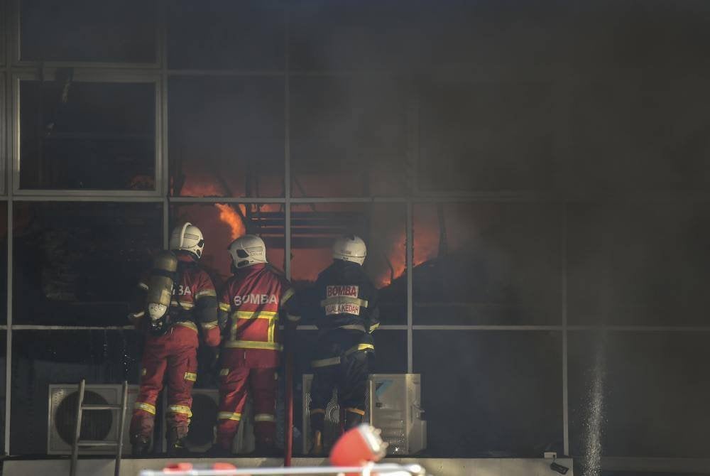 Antara anggota JBPM Kedah berusaha memadamkan kebakaran di gudang alat ganti kenderaan di Kawasan Perusahaan Mergong di sini, pada Rabu. Foto Bernama
