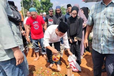 Syed Hussien menyiram air ke atas pusara ayahnya Syed Abdullah di Tanah Perkuburan Islam Kampung Melayu Kluang pada Rabu.