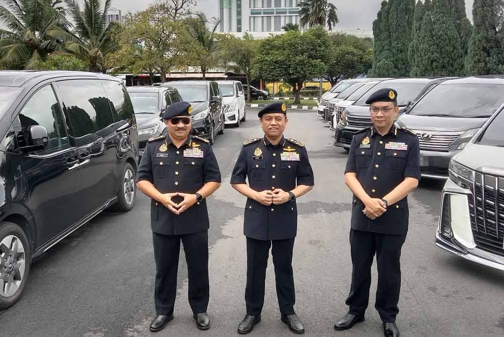 Aedy Fadly (tengah) bersama beberapa kenderaan pelbagai guna (MPV) yang disita menerusi operasi khas dijalankan sekitar Lembah Klang bermula 2 hingga 6 September lalu.