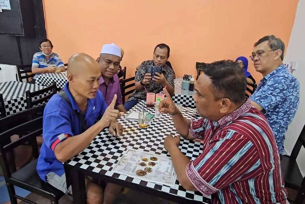 Zolkifly (kanan) membimbing seorang lelaki melafazkan syahadah.