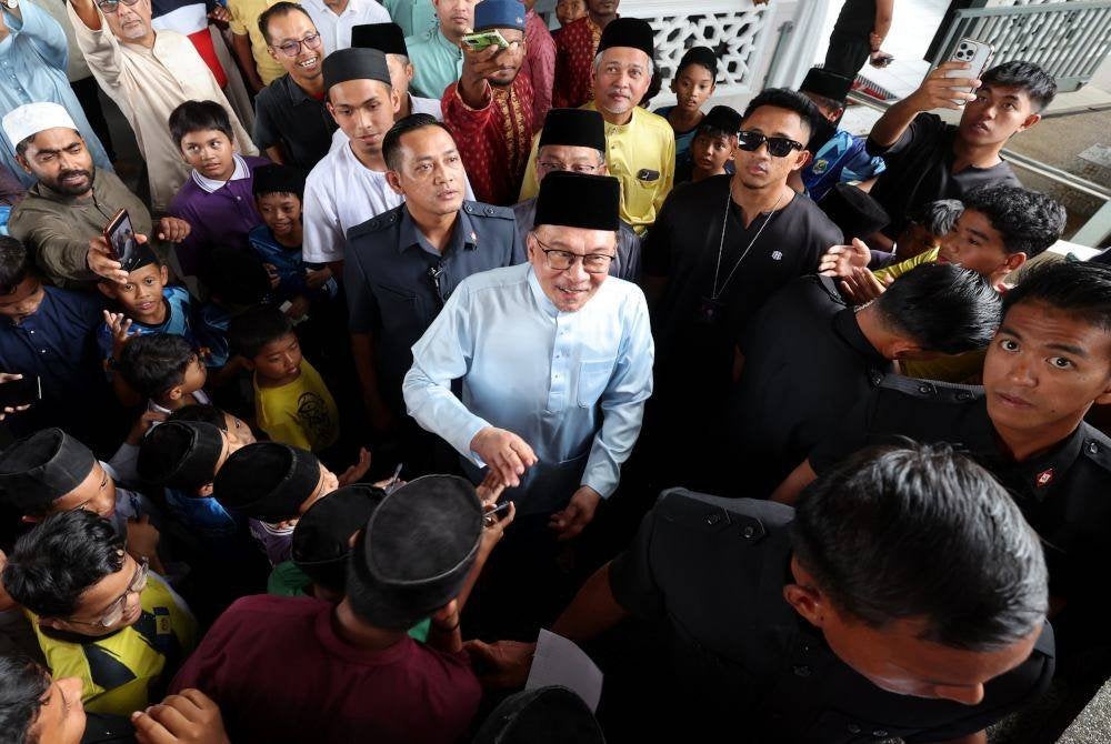 Perdana Menteri, Datuk Seri Anwar Ibrahimi (tengah) beramah mesra dengan para jemaah selepas menunaikan Solat Jumaat di Masjid Al-Iman, Kampung Desa Putra, Sungai Merab, Kajang pada Jumaat. Foto Bernama