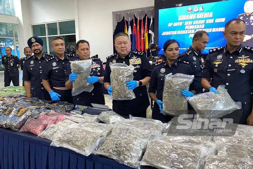 Kok Chin (depan, tiga dari kanan) menunjukkan dadah yang berjaya dirampas menerusi penahanan tiga individu di sekitar Kuala Lumpur pada Rabu.