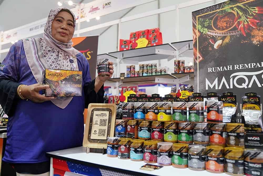 Norita bersama produk keluaran Rumah Rempah MaiQas di Laman Usahawan Desa @ MAHA 2024 pada Jumaat.