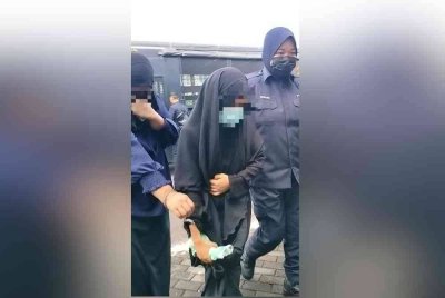 Suspek berusia 34 tahun (tengah) tiba di pekarangan Mahkamah Majistret Alor Gajah di sini, pada Jumaat.