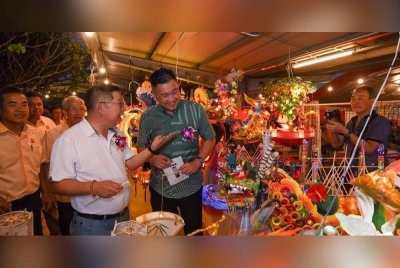 Chia Zen (kanan) melihat tanglung dipamerkan pada Pesta Tanglung Peringkat Negeri Kedah di Dewan SJKC Sin Kwang, di sini pada malam Khamis.